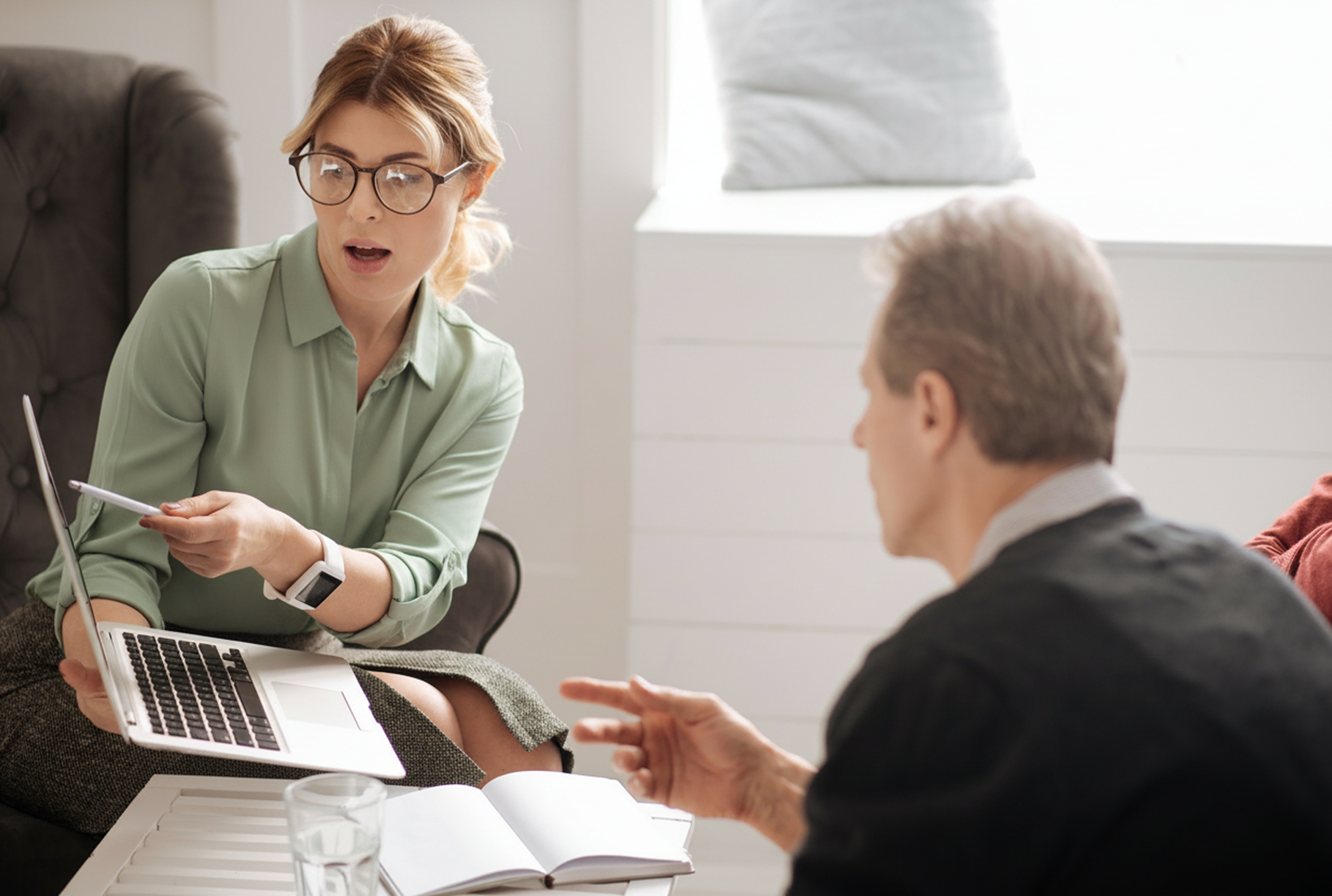 2_people_pointing_talking_laptop_formal_office