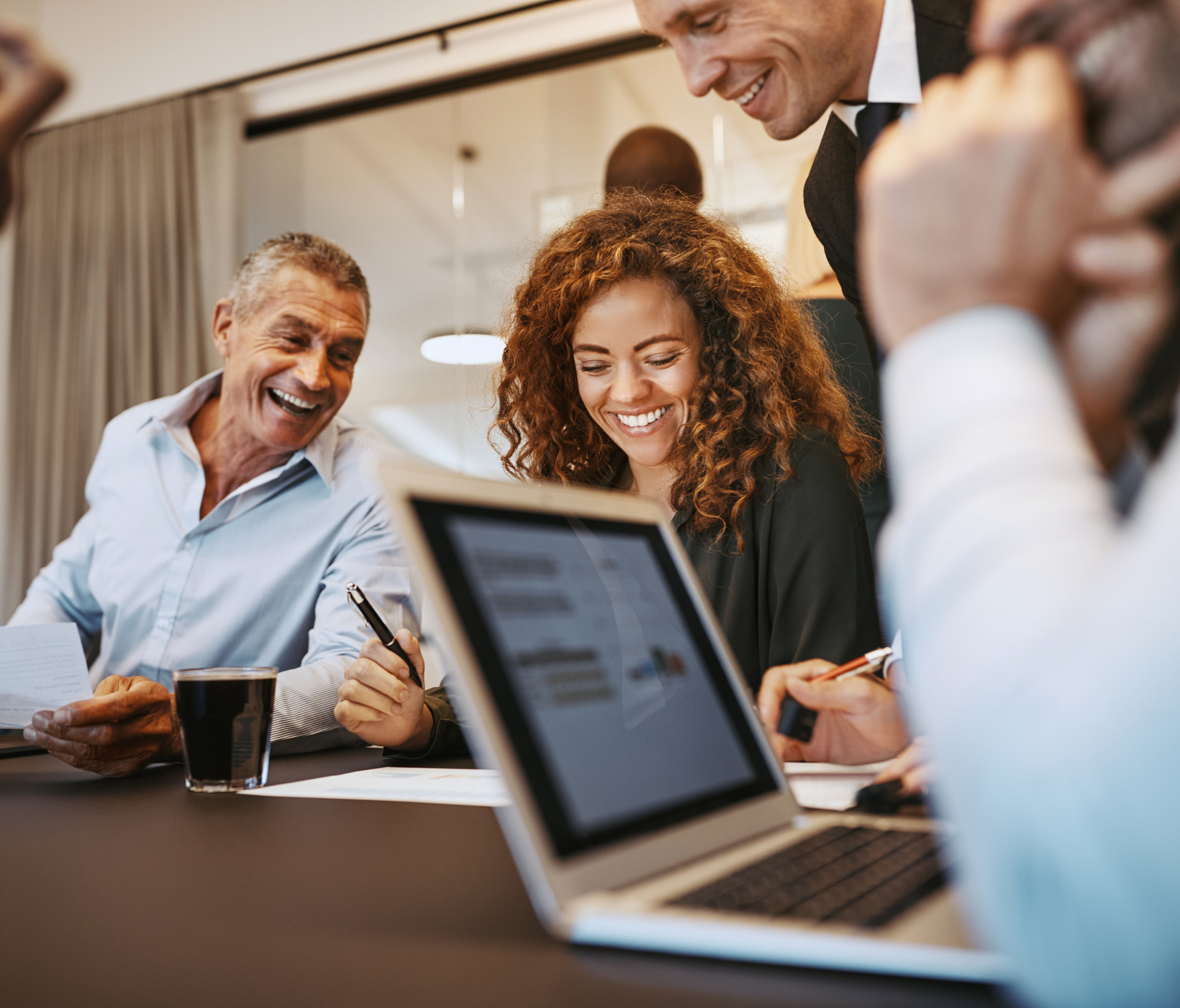 4_people_meeting_smiling_laptop_office